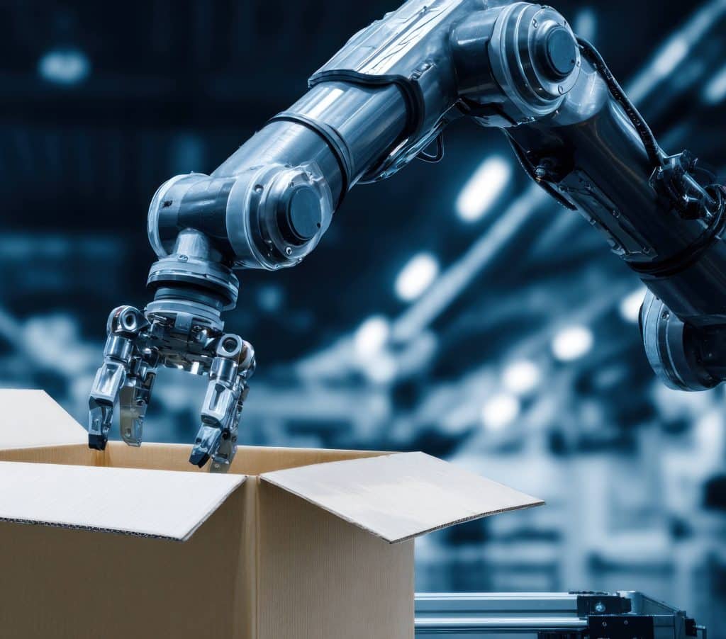 Robot arm with mechanical gripper picking up cardboard box in factory for automation, packaging, manufacturing, and industrial production process with technology and machinery.